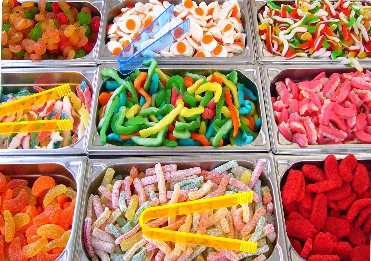 A colour image of 9 bins containing many different types of sweets.